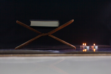 Quran in the mosque - open for prayers The black background of the Muslims around the world placed on a wooden board Quran in the mosque - open for prayers