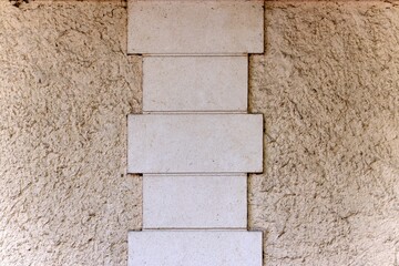 Concrete rectangular tile pattern between sand wall with rough texture cream in color