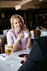 Beautiful businesswoman dressed in the suit drinking coffee. Businesswoman enjoying in the restaurant...