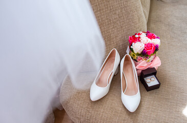 Bridal morning details composition. Top view of wedding rings, beautiful bouquet of pink flowers and leather shoes.