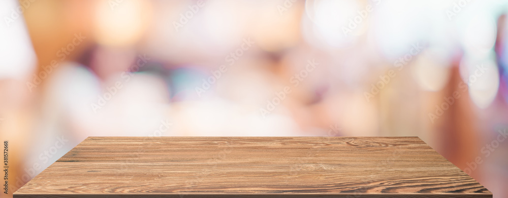 Poster empty wood table with blur people in coffee shop background bokeh light and leaf foreground,mockup f