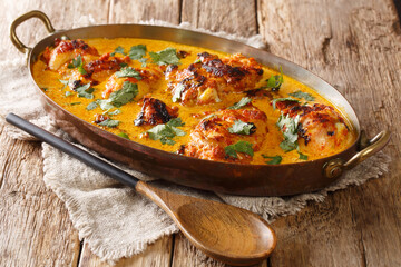 Kuku Paka is a spiced chicken and coconut curry dish that is full of exotic flavours closeup in the pan on the table. Horizontal - obrazy, fototapety, plakaty