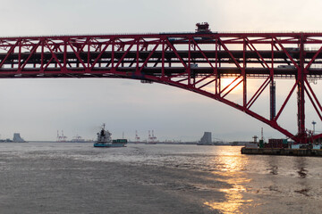 沈む夕日と赤い橋と船