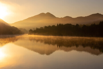 Fototapeta na wymiar 朝焼けの光景が映り込む静かな湖面