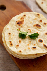 Homemade Roti Chapati Flatbread on a rustic wooden board, side view. Close-up.