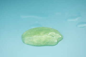 Green cosmetic cream lotion moisturizer strokes on pastel blue. Hygiene, skincare product creamy texture. Beauty face creme smear smudge swatch on color background