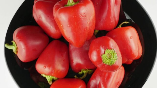 Red pepper on a black plate.Rotate in a circle close-up.