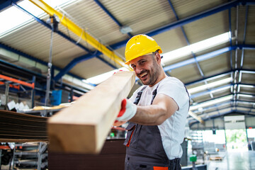 Factory worker checking wood material for further production. Wood industry.
