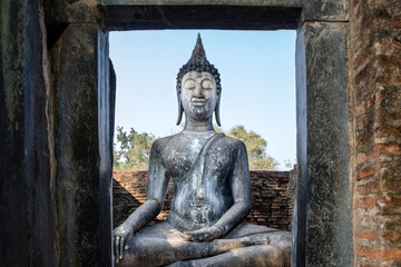 Fototapeta na wymiar An old seated Buddha statue in Sukhothai Historical Park, Thailand