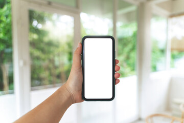 Hand holding empty screen smartphone at coffee cafe.