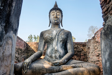 An old seated Buddha statue in Sukhothai Historical Park, Thailand