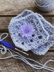 crocheted fragments and flowers on wooden background