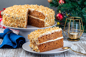 Piece of Carrot cake with cream cheese frosting and walnuts, Christmas decoration on background, horizontal