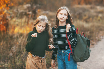 The two sisters return from school and talk as they drive through an open-air autumn park.
