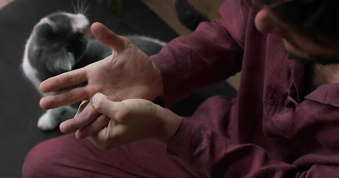 Top close up view of Thailand master pressing point on palm with finger slow motion. Faceless man massaging hand on Asian technique indoors detailed macro shot. Acupuncture oriental medicine recovery