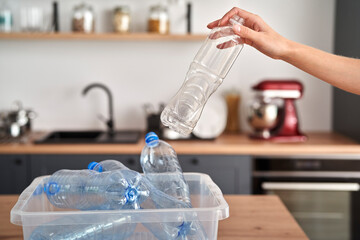 Woman applying colorful glass bottles into the bin