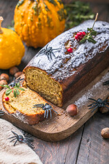 Delicious pumpkin cake on cutting board. Loaf of  bread with pumpkins. Halloween food