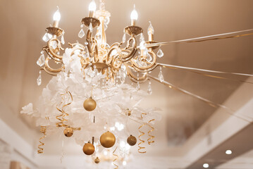 chandelier with light bulbs decorated with Christmas decor with Golden balls