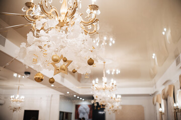 chandelier with light bulbs decorated with Christmas decor with Golden balls