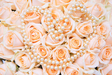 close-up of Pastel cream rose with a pearl necklace in the shape of a heart