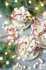 Naklejka premium Cups of creamy hot chocolate with melted marshmallows and candy cane