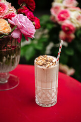 Chocolate milkshake with a straw on the red table