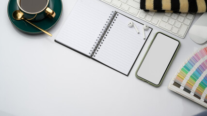 Study table with mock up smartphone, opened notebook, elements and copy space