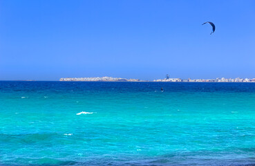 Kite surfing on the sea: on background Gallipoli skyline, Apulia (Italy), whose name means Beautiful City, rests like a mirage on the Ionian coast, roughly 40 km from Lecce.