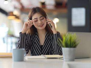 Female office worker talking on the phone while working on office desk