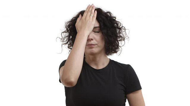 Attractive caucasian woman in black t-shirt looking annoyed, making facepalm and then shaking head disappointed, react to something stupid, standing over white background