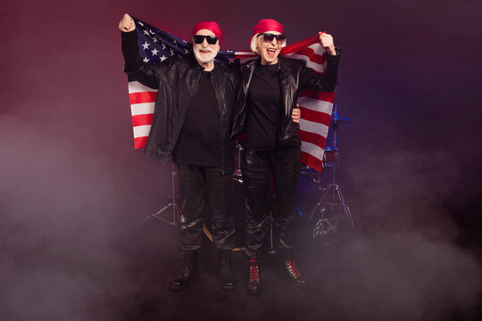 Photo of two retired energetic lady man rock legend group all life on stage photographing hold america usa national flag wear trendy rocker leather outfit isolated black color background