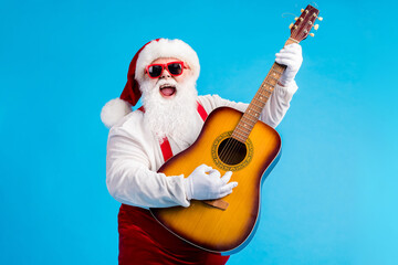 Photo of crazy funky santa claus with grey beard playing guitar instrument on x-mas christmas party...
