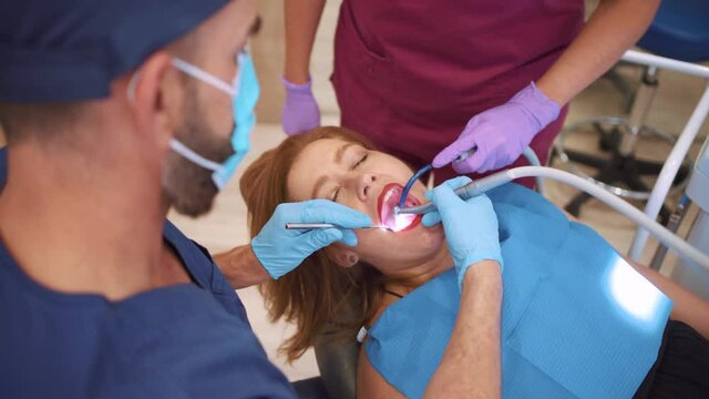 Stock video of woman with her mouth open during dentist revision.