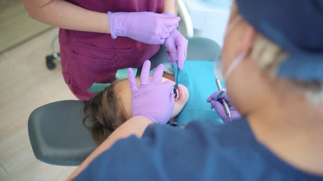 Stock video of dental clinic workers doing treatment to a young patient.