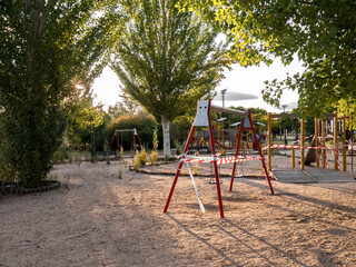 Swings and public parks closed with plastic tapes with the text: "do not pass" "forbidden to pass" due to the ban in the community of Madrid due to the coronavirus in San Sebastián de los Reyes