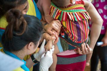 Volunteer nurse taking blood sample from poor patient in Vietnam