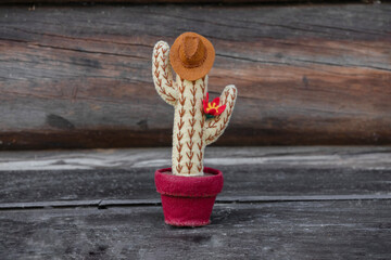 Card of cactus felt toy Cowboy with hat is on old wooden texture background. Concept father's day.