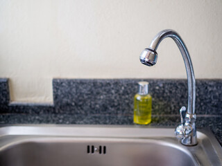 Fototapeta premium Faucet and bottle of dishwashing liquid On the sink.