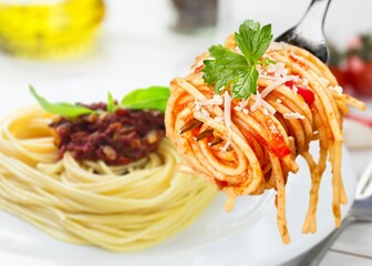 Metal fork with delicious spaghetti and sauce