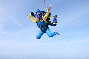 Fototapeta na wymiar Skydiving. Tandem jump. Man and woman are in the sky.