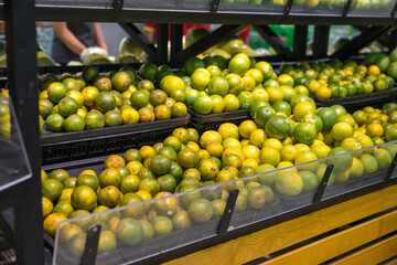 Fresh healthy fruits on shelves in supermarket. Green orange