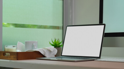 Mock up laptop on computer table with mug and candle in wooden tray