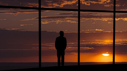 The man standing on the building against the beautiful sunset