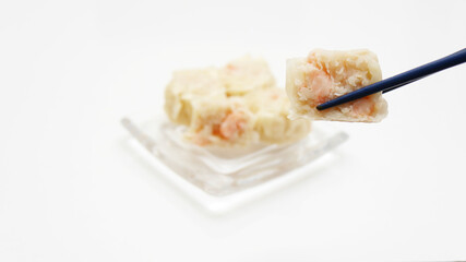箸でつまんだえびシューマイ