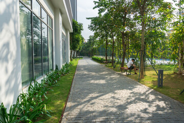 Urban walking road among green trees inside modern apartment building area in big city
