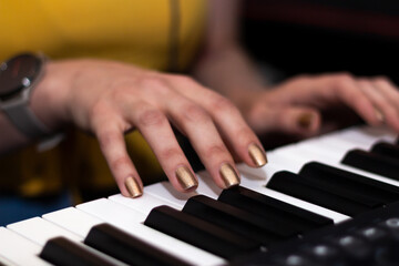 Girl Playing on a MIDI Keyboard with Golden Nails