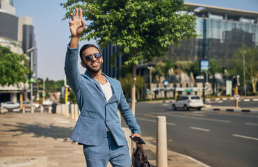 Indian Arabic businessman waving down taxi cab