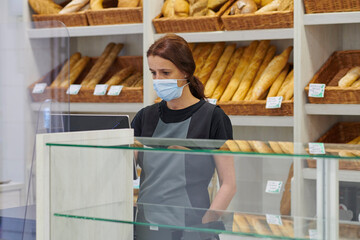 young red-haired worker working in the bakery. Small business concept. protection measures against covid 19 in small businesses