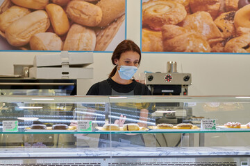 young red-haired worker working in the bakery. Small business concept. protection measures against covid 19 in small businesses