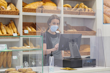 young red-haired worker working in the bakery. Small business concept. protection measures against covid 19 in small businesses